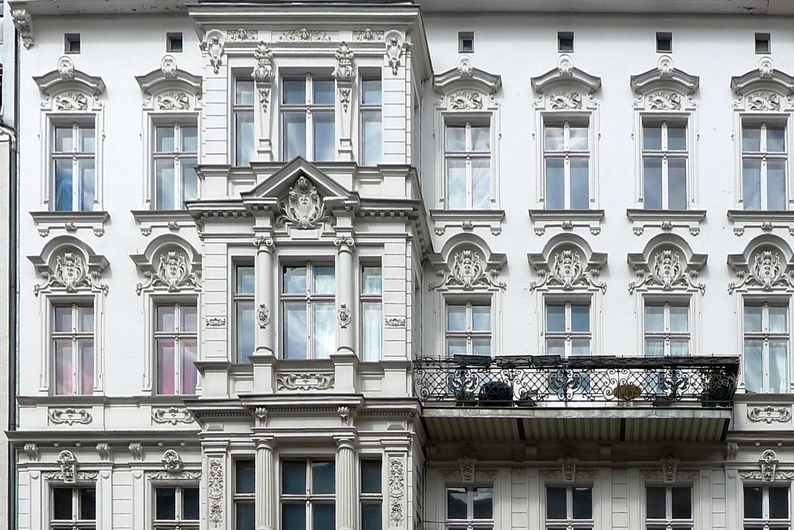 Gründerzeitfassade eines Mehrfamilienhauses mit Stuckornamenten, frontal aufgenommen